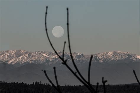 Full Moon Over Snow Capped Mountain Range Stock Photo Download Image