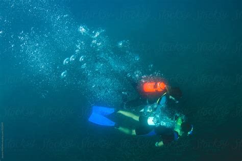 Scuba Divers Diving Deep Underwater By Stocksy Contributor Jovana Milanko Stocksy