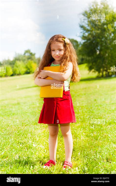 Portrait Of Beautiful 6 Years Old Girl Standing In The Park With Books