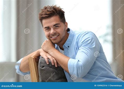Portrait Of Handsome Young Man Sitting On Chair Stock Photo Image Of