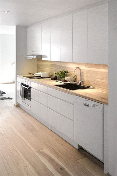 These minimalist kitchens manage to incorporate the necessary appliances and seating while also ensuring that each space is imbued with its own sense of course, where minimalism is at play, the combination of white and wood cannot be far behind. stylish-white-kitchen-with-wooden-backsplash-and-led-lights