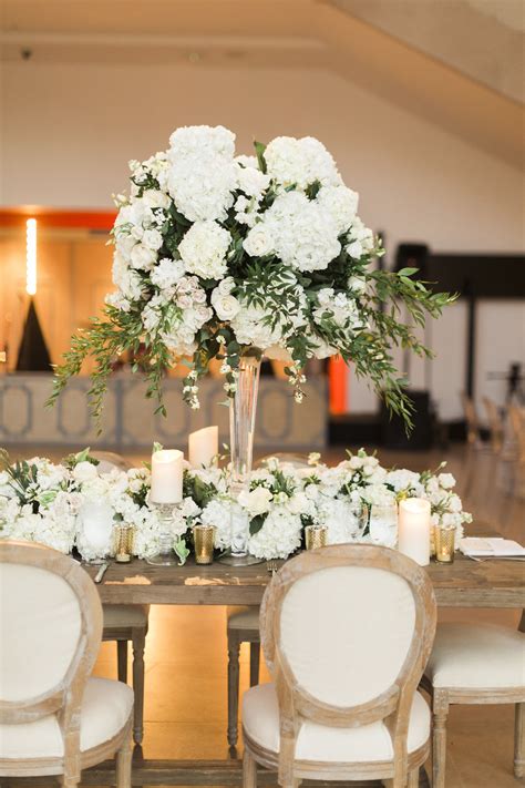 A Table With White Flowers And Candles On It