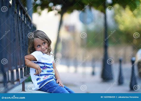 A 4 Year Old Girl Leaning On A Railing Looks To The Side Stock Image