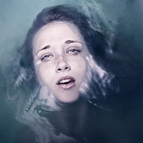 A Woman Is Floating In The Water With Her Eyes Closed