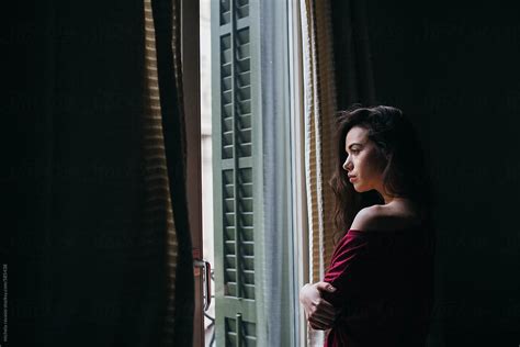 View Brunette Woman Looking Out The Window By Stocksy Contributor Michela Ravasio Stocksy