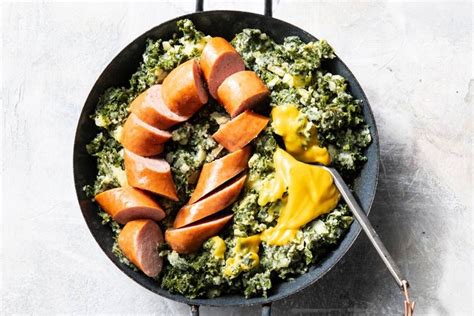 Sausages And Greens In A Skillet With Mustard On The Side Ready To Be