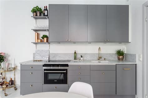 Best of all, it pairs beautifully with a wide array of other colors and is the perfect base to build upon in a kitchen. scandinavian-small-apartment-grey-kitchen | Hall of Homes