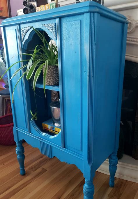 a blue cabinet with a potted plant in it