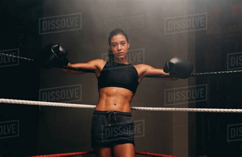 Muscular Female Athlete Wearing Boxing Gloves Stares At Camera While