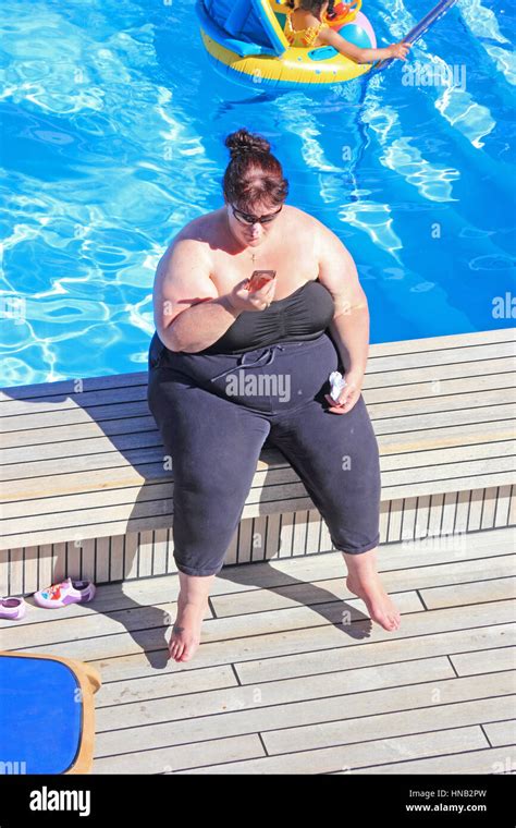 Obese Lady Sat On Edge Of Swimming Pool Stock Photo Alamy