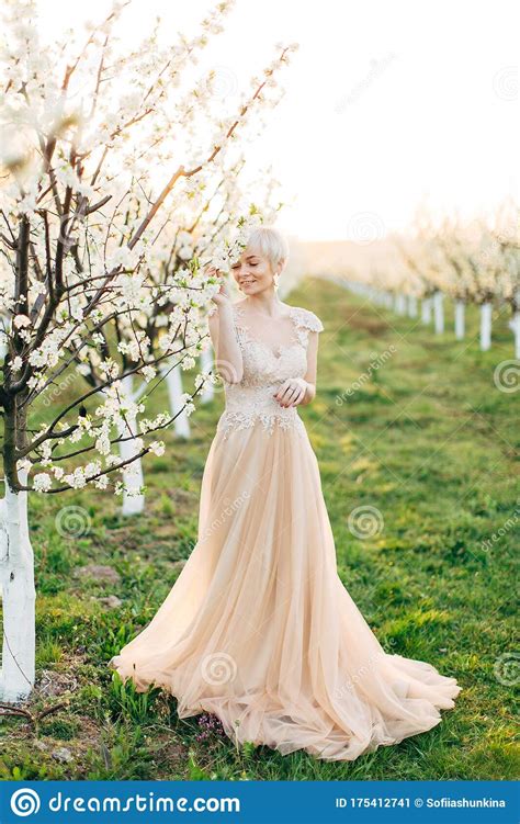 The Image Of A Beautiful Bride In A Blossoming Garden Standing Near The Flowering Tree Spring