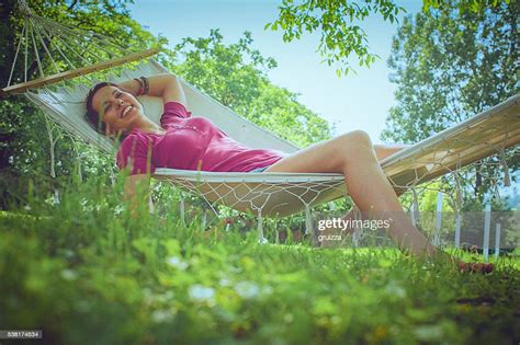 Young Carefree Woman Relaxing In A Hammock In The Garden High Res Stock