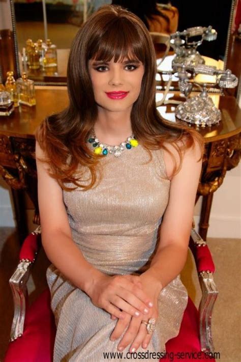 A Woman Sitting In A Red Chair Wearing A Dress And Jewelry On Top Of