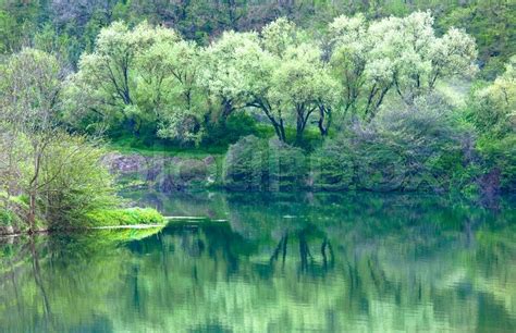 Beautiful Lake With Spring Trees And Rocks Mountain Reflection In Water Surface Stock Photo