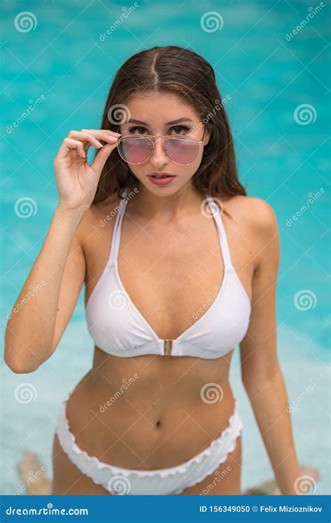 Attractive Woman Posing By The Pool With Cool Sunglasses Stock Photo
