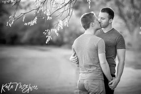 Two Men Kissing Each Other Under A Tree