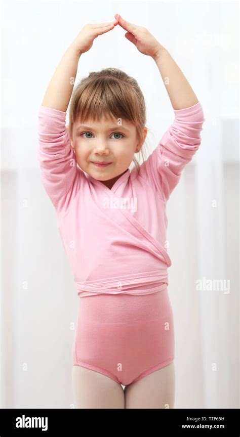 Little Cute Girl In Pink Leotard Making New Ballet Movement At Dance