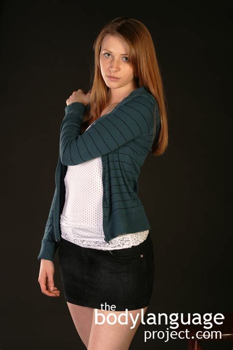 Female standing with folded hands smiling at camera. Non Verbal Body Language Dictionary ::P:: - Body Language ...