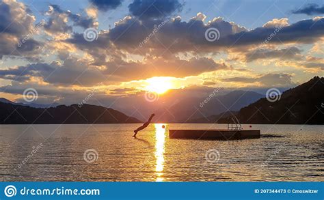 Millstaettersee A Man Jumping Into The Millstaettersee Lake From A