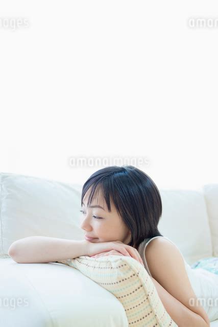 ソファに寝転ぶ女性の写真素材 FYI01571514 ストックフォトのamanaimages PLUS