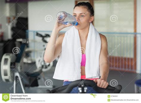 Tired Woman Drinking Water While Working Out At Spinning Class Stock