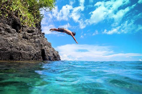 Man Jumping Off Cliff Into The Ocean Photograph By Konstantin Trubavin