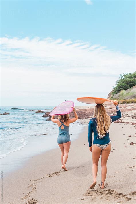 Two Women Walking On The Beach Carrying Surfboards On Their Heads Stocksy United