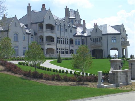 a large white mansion with many windows and lots of green grass in