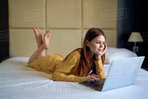 Caucasian Woman Laying On Bed Using Laptop Stock Photo Dissolve