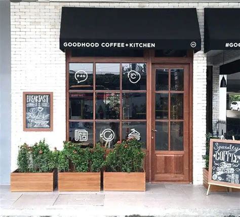 The Outside Of A Coffee Shop With Wooden Planters And Chalkboards On
