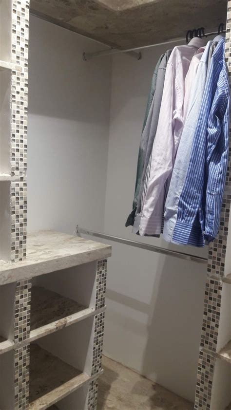 A Closet With Shelves And Clothes Hanging On Hooks