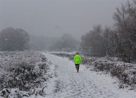 Lonely Runner Running At Country Road Covered With Snow Editorial