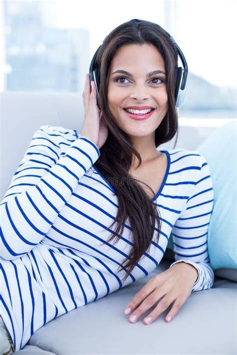 Smiling Beautiful Brunette Relaxing On The Couch And Listening Music