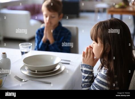 Cute Children Praying Before Meal At Home Stock Photo Alamy