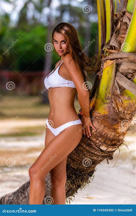 Beautiful Girl In White Bikini Posing At The Tropical Beach Stock Photo