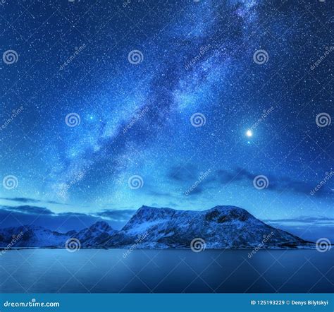 Milky Way Over Snow Covered Mountains And Sea At Night In Winter Stock