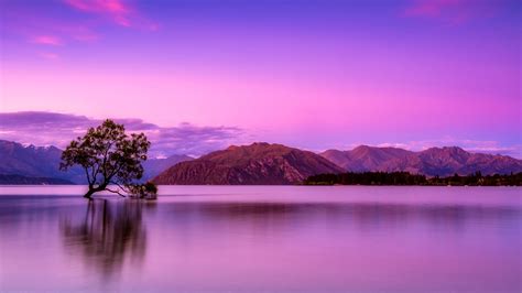 Landscape Of Mountains And Body Of Water Under Purple Sky