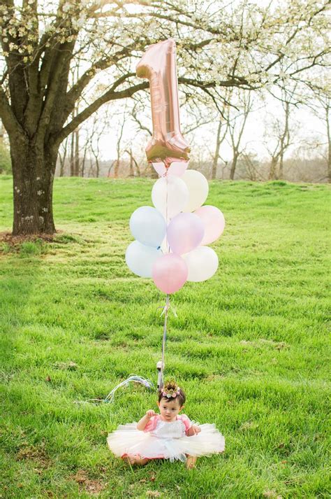 1st birthday photoshoot outdoors using pastel colors and rose gold number one balloon 1st