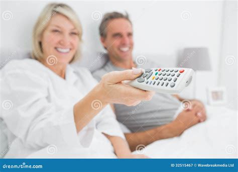 Smiling Couple Watching Tv In Bed Stock Image Image Of Apartment