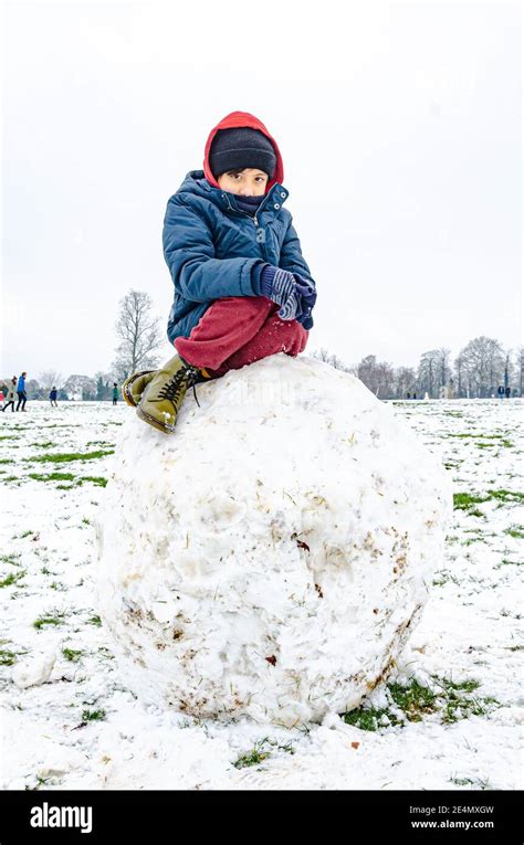 Ein Junge Sitzt Auf Einem Riesigen Felsbrocken Aus Schnee Im Prospect Park In Reading Berkshire