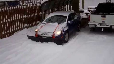 Nordic V Plow On A Gravel Driveway Pushed By A Small Car