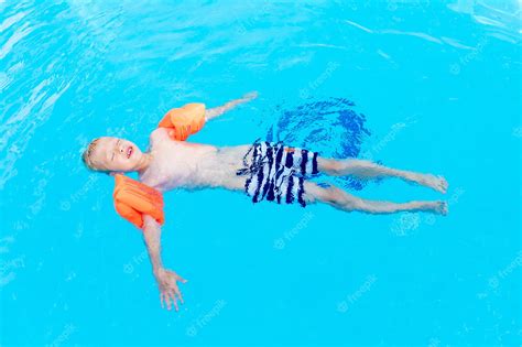 Premium Photo A Happy Baby Boy Is Lying On The Water Or Learning To