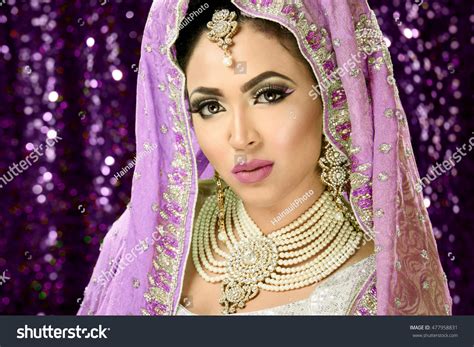 伝統的なインド人のパキスタンの花嫁に扮し、厚化粧と宝石を身に着けた美しい女の子のポートレート写真素材477958831 shutterstock