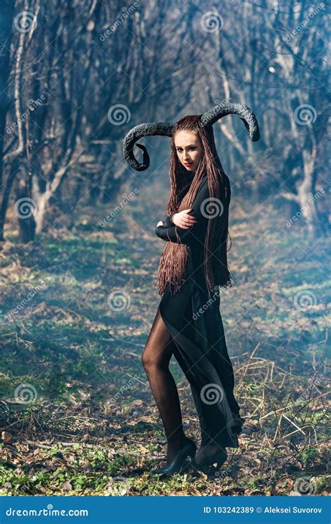 Beautiful Woman Dressed As A Fairy Witch In Raincoat And With Horns For Halloween Stock Image