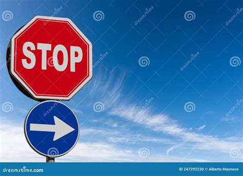 Stop And One Way Road Sign Against A Clear Blue Sky And Clouds Stock