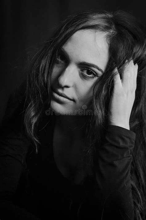 black and white portrait of a beautiful italian girl with long hair with her hand in her hair