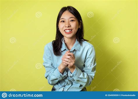 Happy Korean Woman Holding Hands Together Posing Over Yellow Background Stock Image Image Of