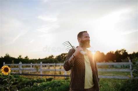 Happy Mature Farmer Man With Garden Tool Outdoors In Field Stock Photo