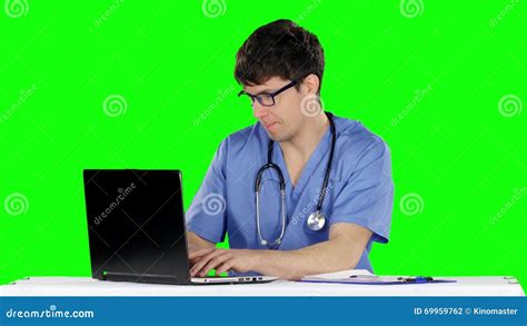 Friendly Happy Male Doctor In The Office Using Laptop Green Screen