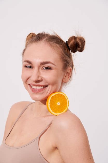 Premium Photo Happy Smiling Clean Skin Woman Holding Orange Near The Face